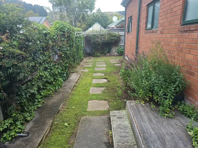 The same paver path cleared and weeded with the grass trimmed back